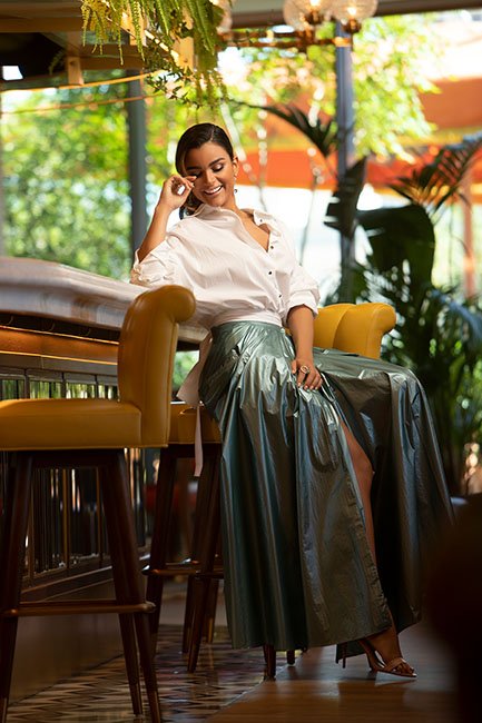 Clarissa Molina fotos revista hola wearing a long shiny skirt and white shirt sitting at the bar of the terrace of the four seasons hotel madrid